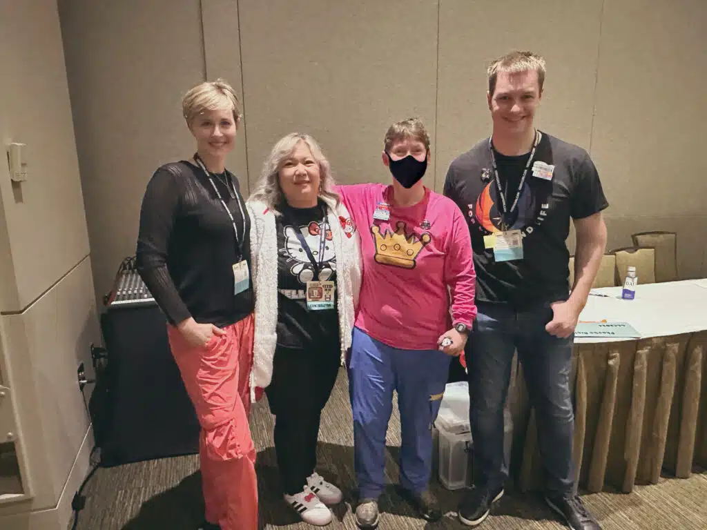 Presenters and Panelists from GeekGirlCon 2024's panel "Women’s Brick Initiative: Inspiring Women and Girls to Create With LEGO Bricks" stand together for a photo.  From left to right: Kelly Bartlett, Phoebe Arcilla, CJ, and Caleb Inman.